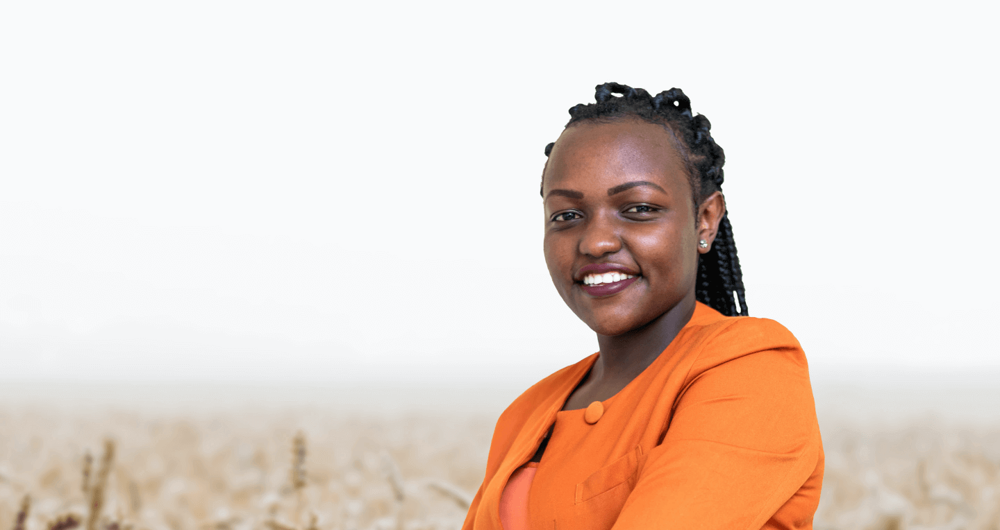 A photo of Alice wearing an orange jacket and posing with her arms folded